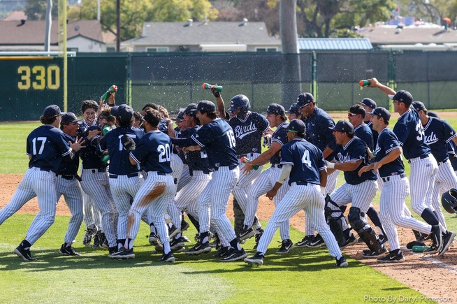 Teammates surround Alonso Reyes, who drove in the game-winning run in the 9th inning