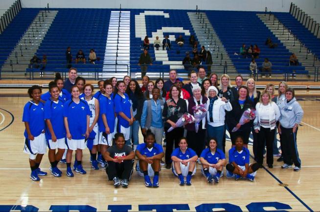 Members of the 2012-13 team with former players who attended a homecoming to help dedicate the renovated gym.