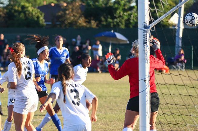 Amber Whitmore (white headband) heads home the Falcons second goal in a 2-0 win
