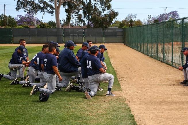 Ken Gaylord (seated) meets with his team after they were eliminated from the post-season