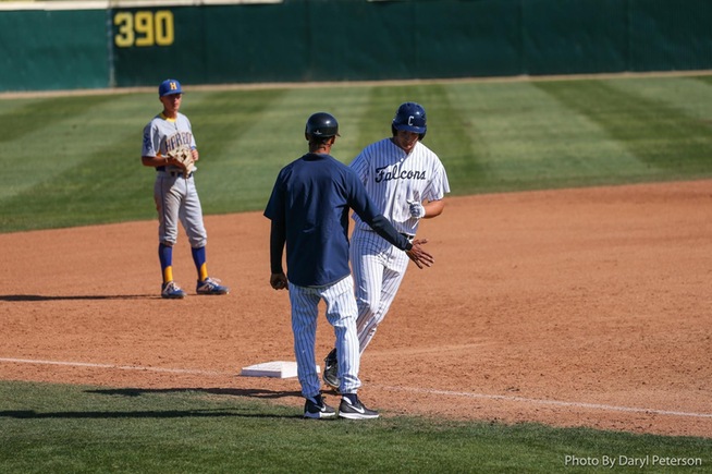 Cody Ahrens is greeted by third base coach Ron Perodin after his home run