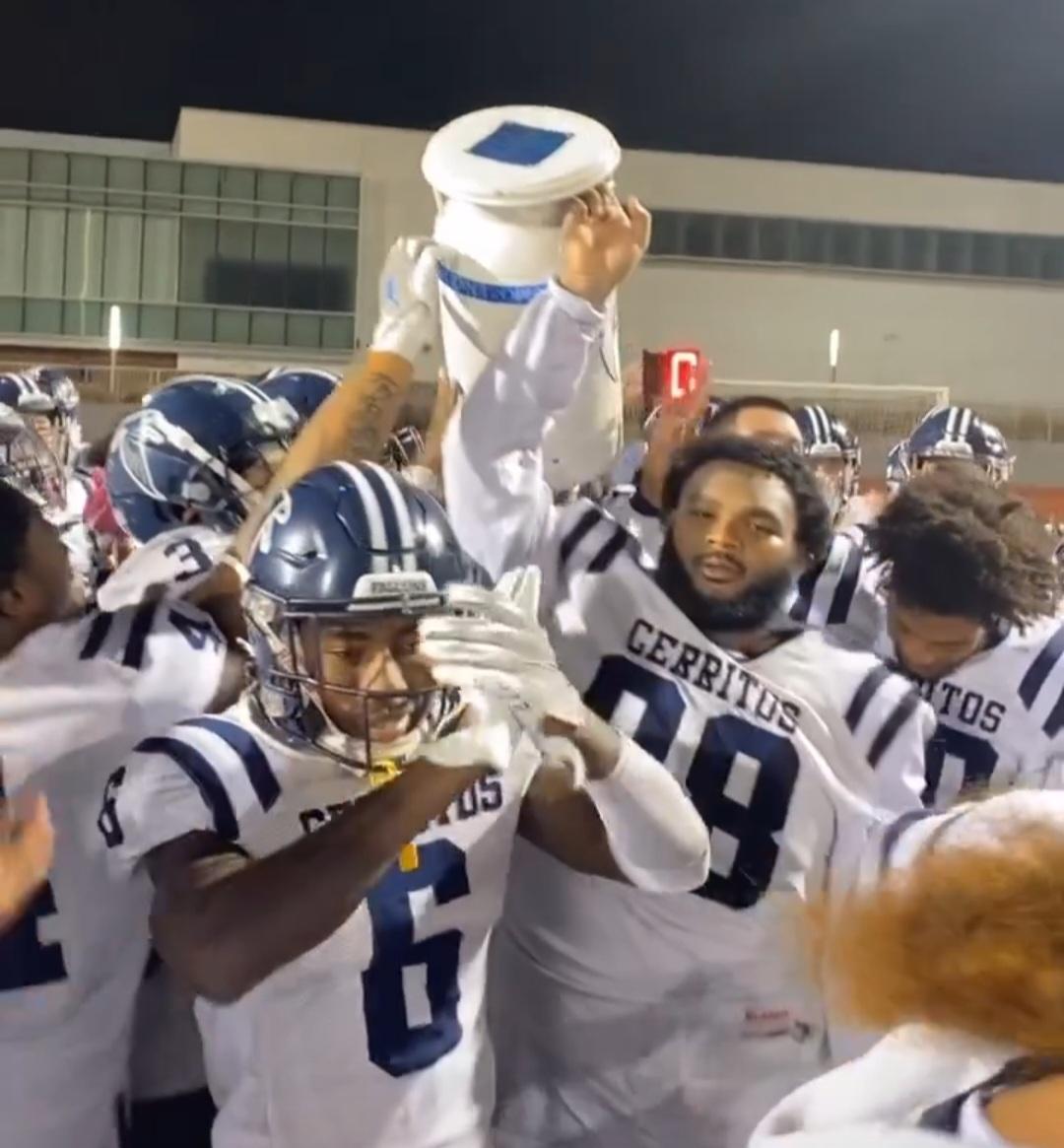 Daleoun Arthur (98) and the Falcons lift the Milk Can Trophy after their 22-20 win over El Camino