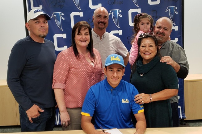 Kevin Diaz (seated) is joined by head coach Benny Artiaga, Athletic Director Maria Castro, Dean of Athletics Rory Natividad and his family, as he signs his National Letter of Intent with UCLA