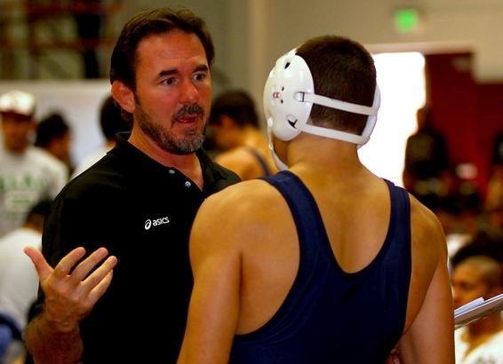 Head coach Donny Garriott meets with one of his wrestlers at a tournament.