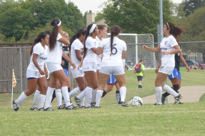 The women's soccer team celebrates one of their five goals against Cisco (TX)
